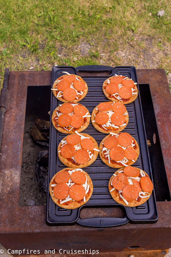 mini naan pizzas on cast iron griddle over fire