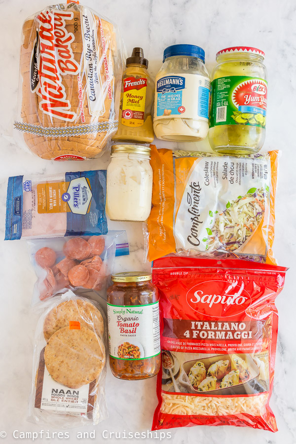 ingredients for camping lunches including bread meat coleslaw condiments