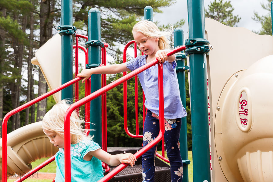 two girls on a playground running down the stairs