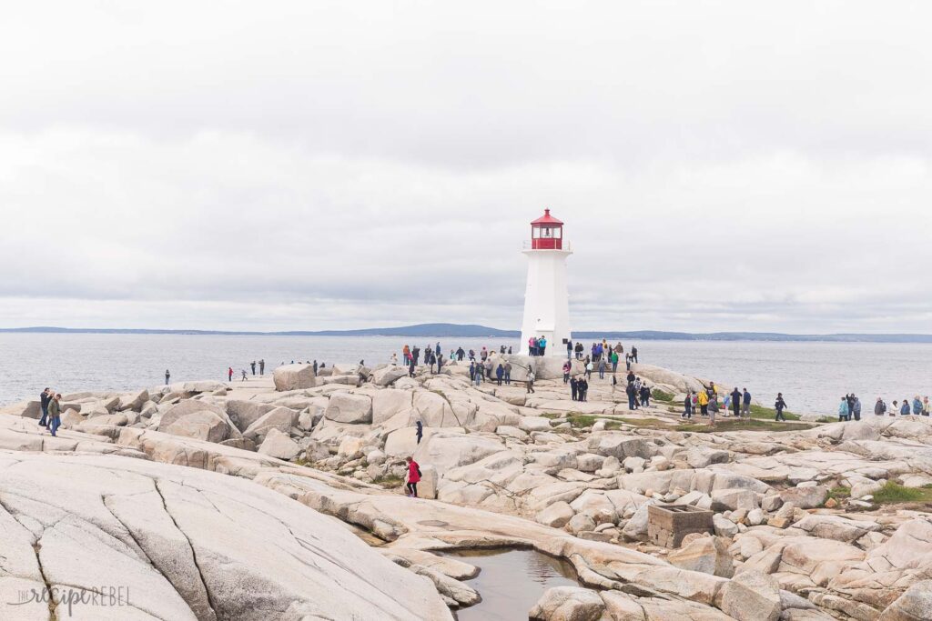 peggy's cove lighthouse on the rocks with the ocean behind