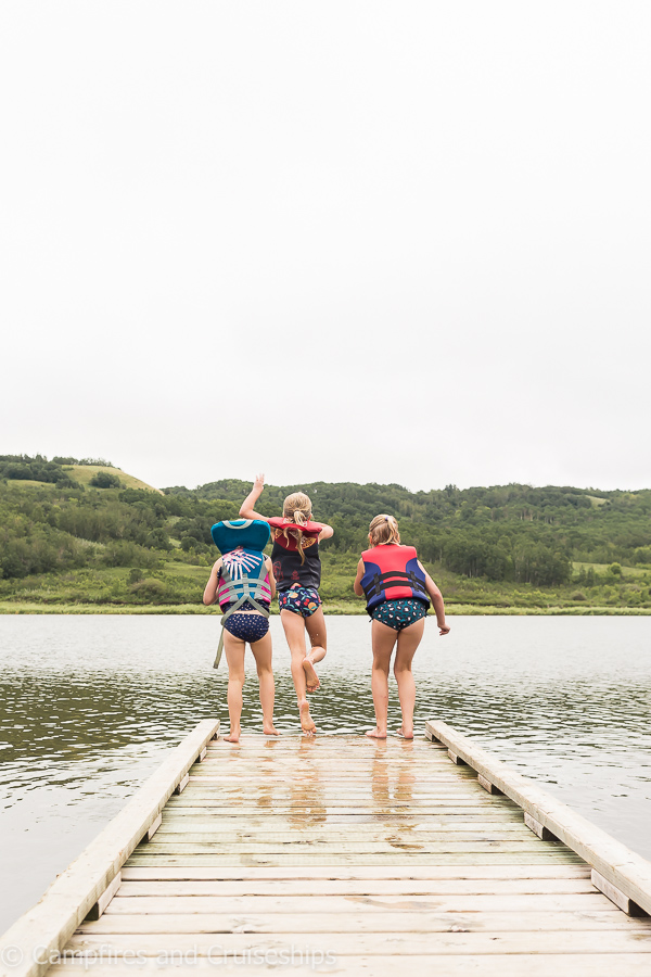 three girls jumping off the dock at asessippi lake manitoba