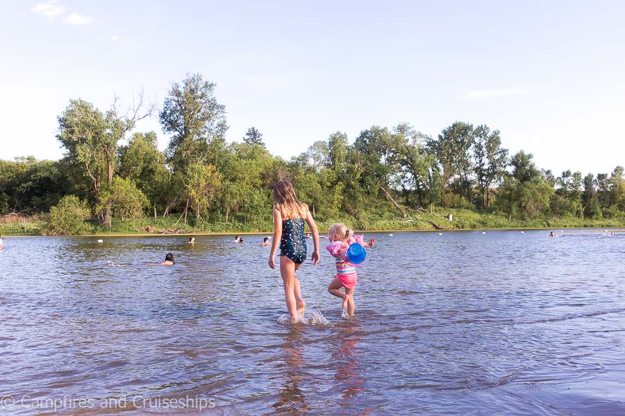 two girls walking in the water at kiche manitou beach